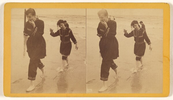 Unknown, [Man and woman dressed in similar costumes walking across beach]