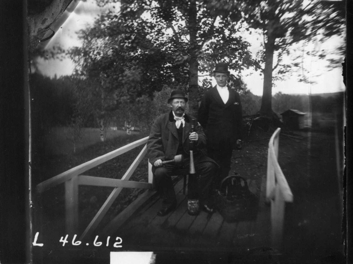 Fredrik Emil Faye, Dobbeltportrett, sittende kommandør Niels Juel, ca. 1880. På trebro. Fra portrettserie av personer som bodde på eller besøkte Dal gård, Ullensaker, fotografert av gårdens eier, kammerherre Fredrik Emil Faye (1844-1903) i årene 1875-1900.