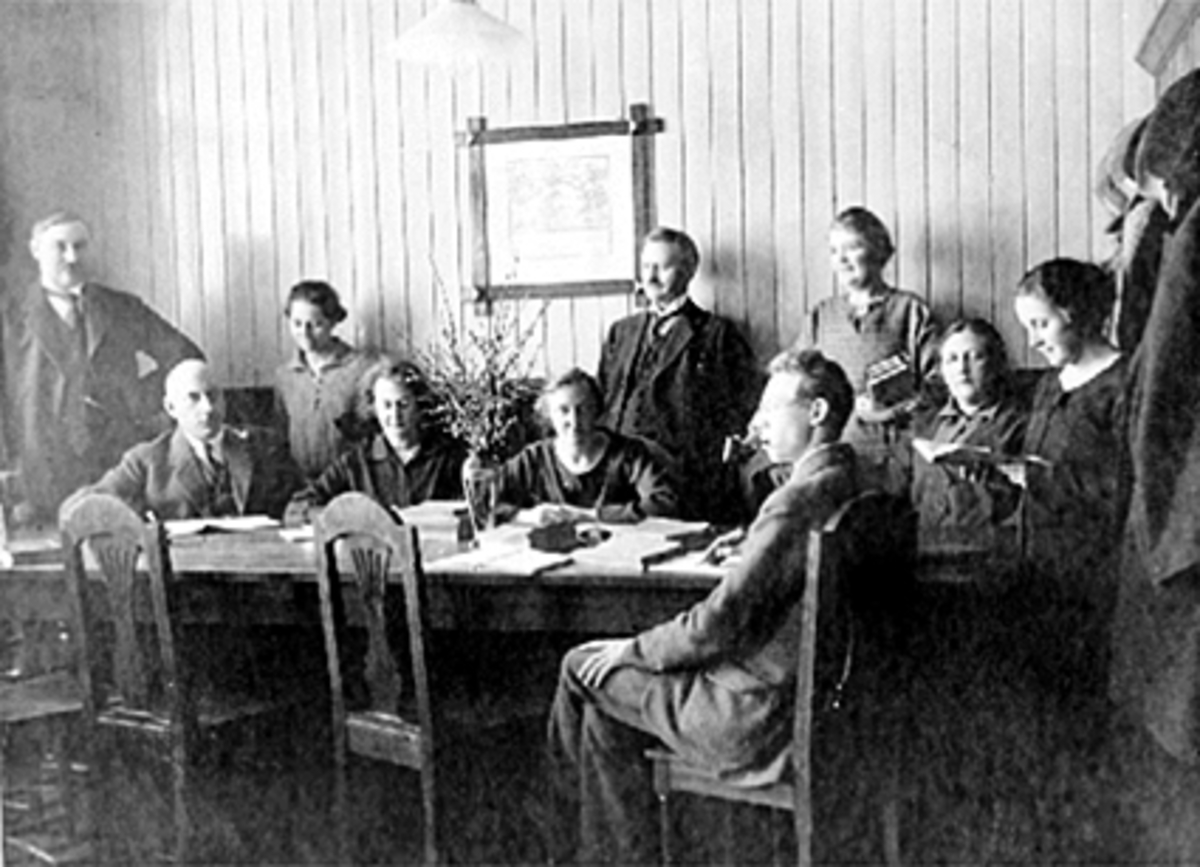Anno Domkirkeodden, Interiør lærerværelset, 10 lærere. Foran bordet til høyre: Oskar Vangen, til høyre Magnhild Sjetne, Sigrid Bjerkli, Anna Torp Bjerkli, Edvard Bergseng, Ragnhild Rosenberg, Marie Refsdal, maria Lunaas, Jørgen Kvam og stående helt til venstre K. O. Bjerkli. Storhamar Skole.