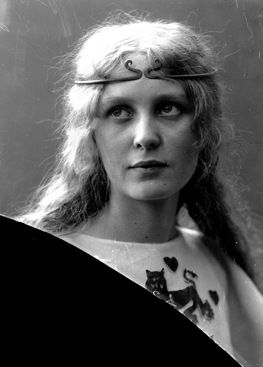 Solveig Lund, Brystportrett av kvinne i drakt med riksvåpen og hårsmykke.