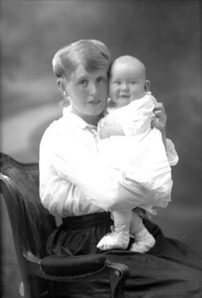 Gustav Borgen, Gruppeportrett, sittende kvinne med spedbarn i fanget. Fru Gunvor Hansen.