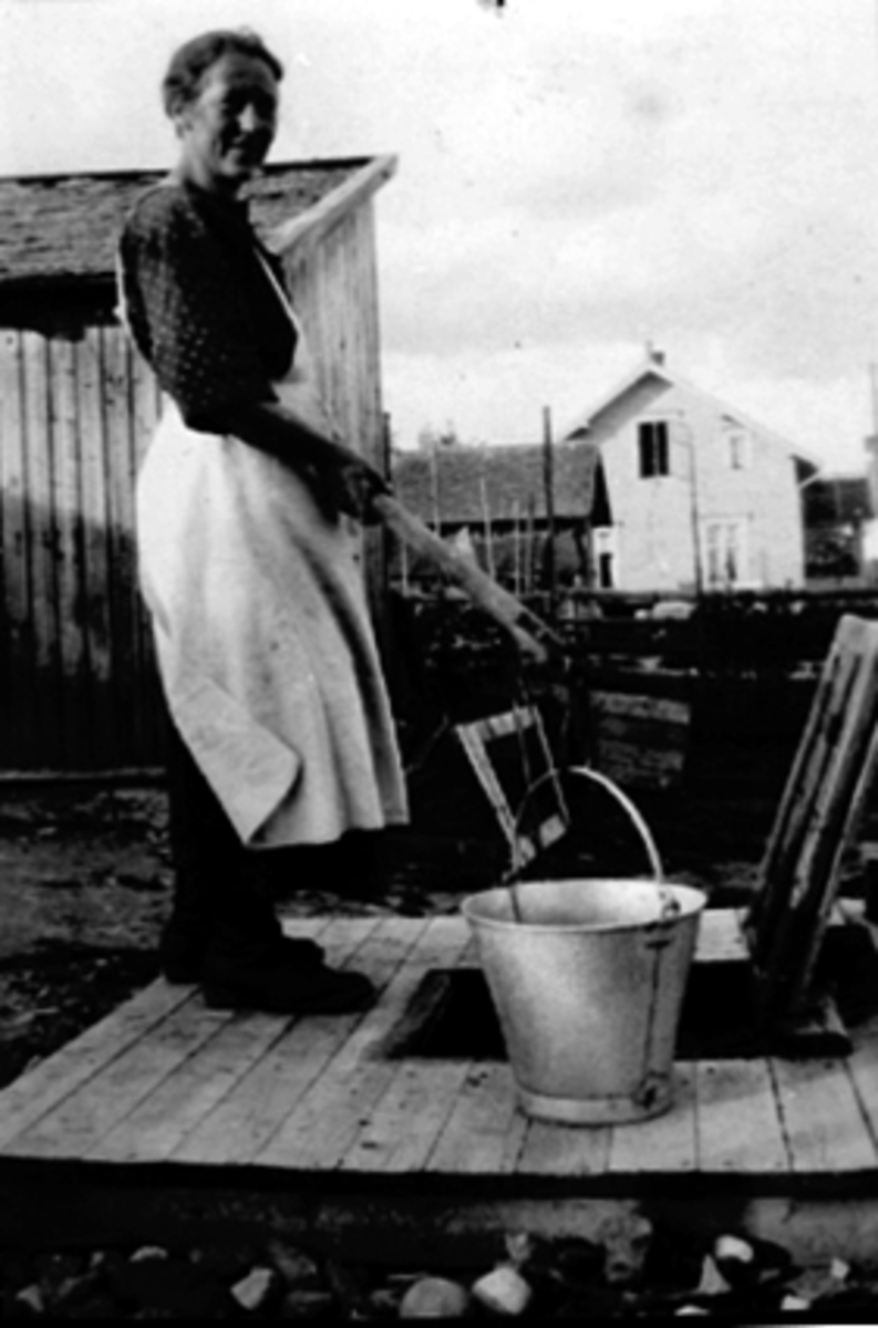 Anno Domkirkeodden, Brønn, sinkbøtte, ukjent kvinne, forkle, Vang. H? 1920-årene.