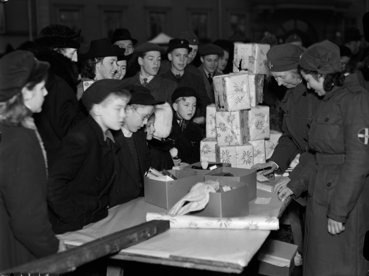 Paul Sandberg, "Lottornas julmarknad gav rekordinkomst. Fullkomlig folkträngsel på Fyristorg" - försäljning av fältjulklappar, Uppsala december 1942
