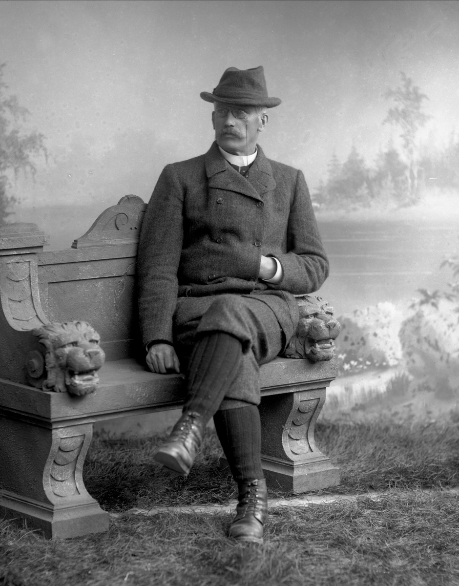 Gustav Borgen, Portrett, mann i ytterklær på benk. Strømper og nikkers.