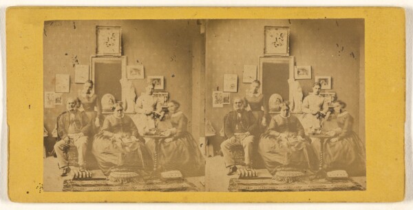 Unknown, [Family portrait, taken in living room, photographs and paintings on the wall behind]