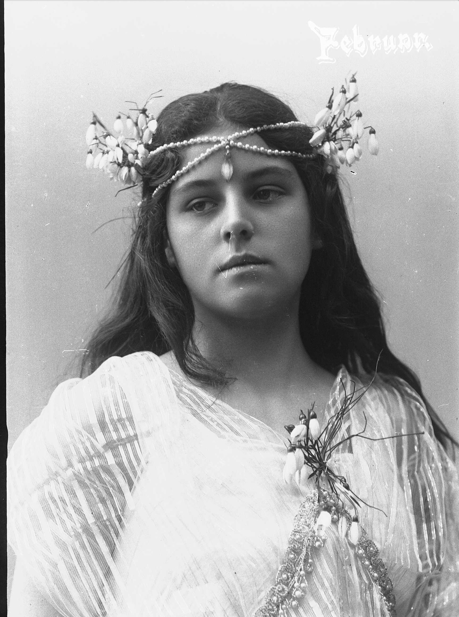 Solveig Lund, Studioportrett av kvinne i drakt med blomster og smykker i håret.