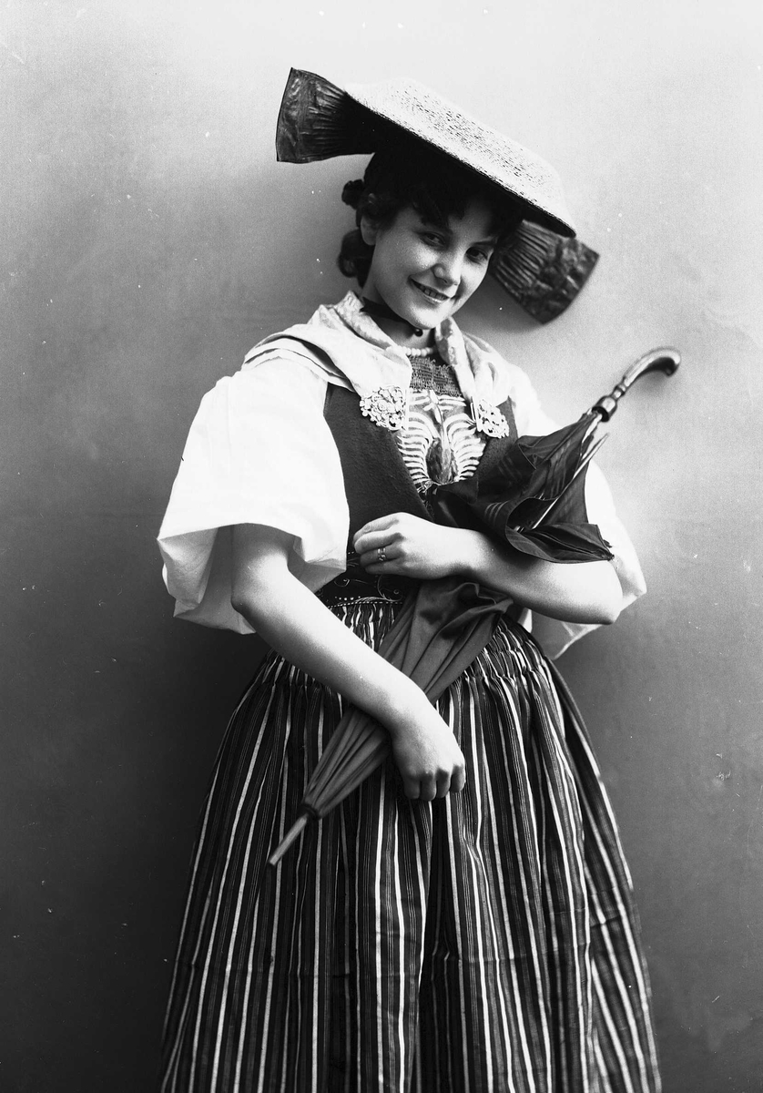 Solveig Lund, Kvinne i drakt og hatt, med paraply.