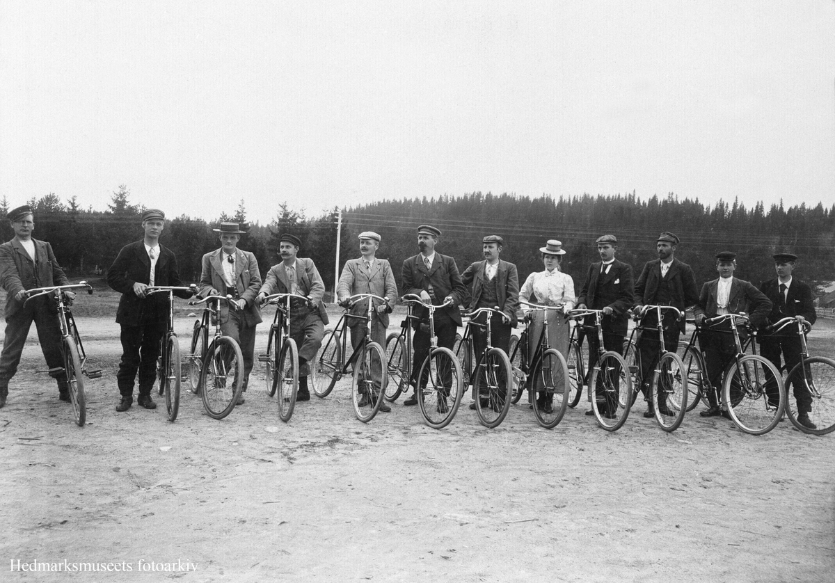 Anno Domkirkeodden, GRUPPE 11 MENN OG EN DAME MED SYKLER PÅ UTFLUKT FRA ÅDALSBRUK SOMMEREN 1899, TUREN GIKK TIL RENA. NR. 7 OG 8 FRA VENSTRE ER: BAKER JOHAN HAUGEN WANG OG KJÆRESTEN JULIE AALSVOLD, FOTOGRAFERT PÅ RENA. SE HEFTET "DET VAR ENGANG ET INDUSTRISAMFUNN AADALS BRUG 1842-1928" SKREVET AV ÅSE KROGSRUD, UTGITT …