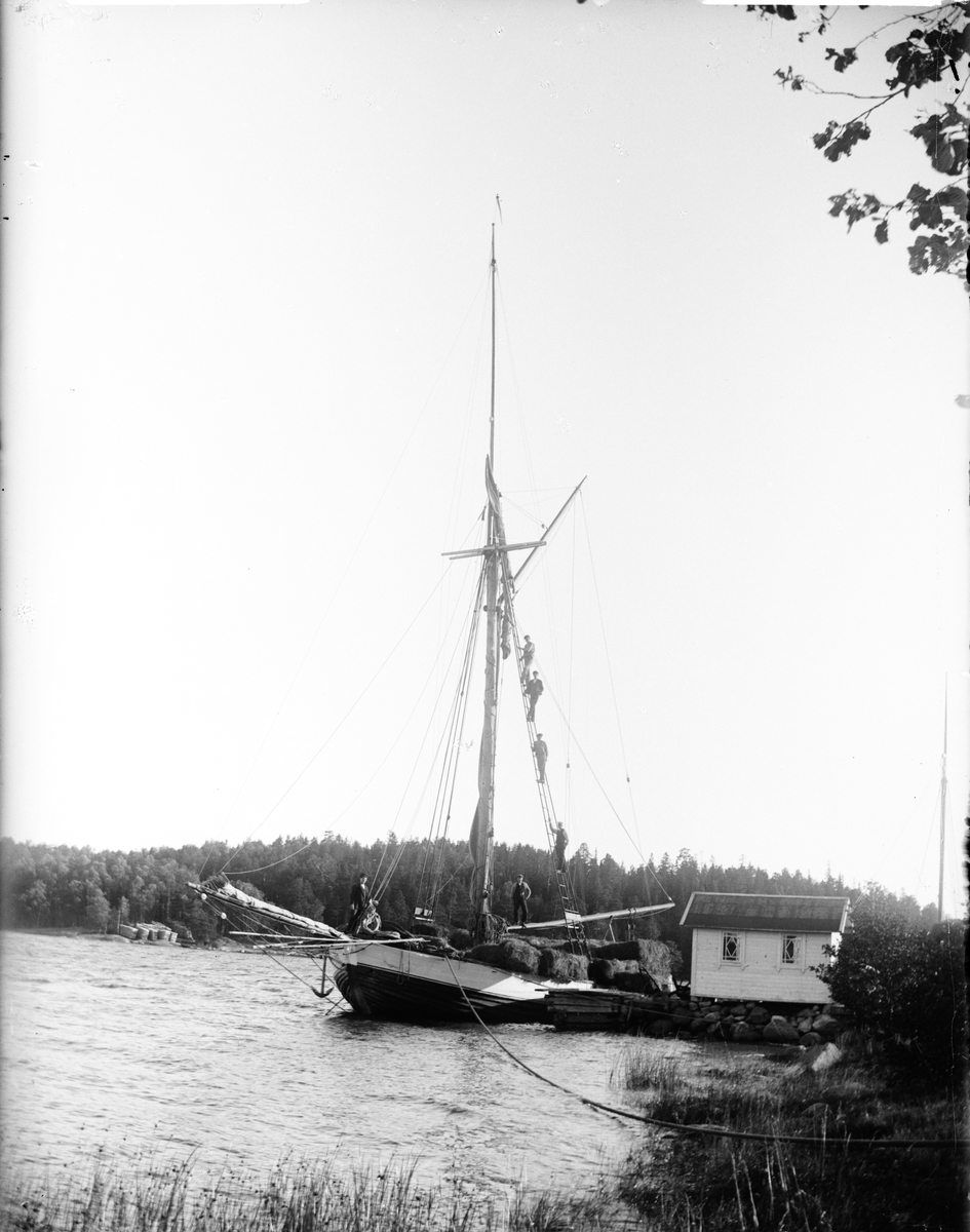 Per Elis Edhlund, Men on sailboat loaded with bales, Östhammar, Uppland 1902