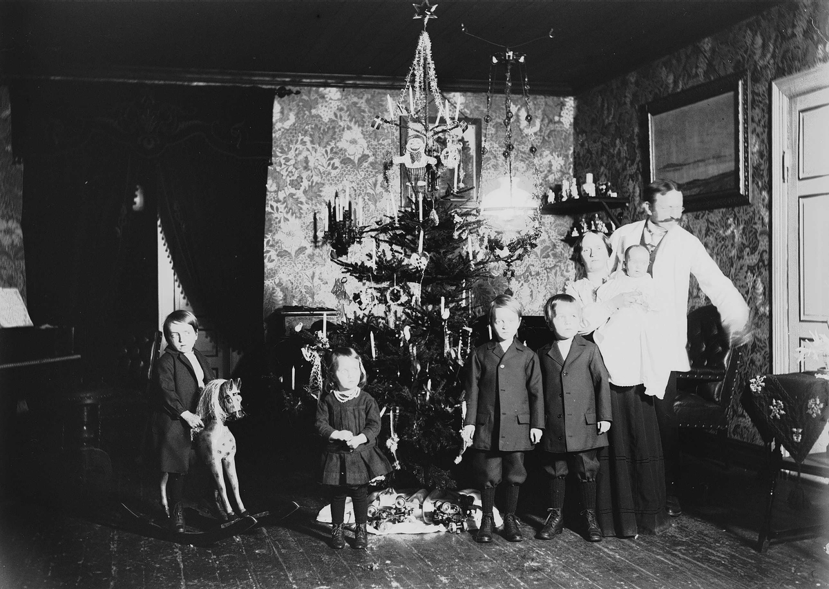 Axel Quinsgaard Wiborg, Familie feirer jul med juletre og gyngehest. Interiør, ant. fra Nedre Digerud, Frogn, Akershus, hos familien Quinsgaard Wiborg.