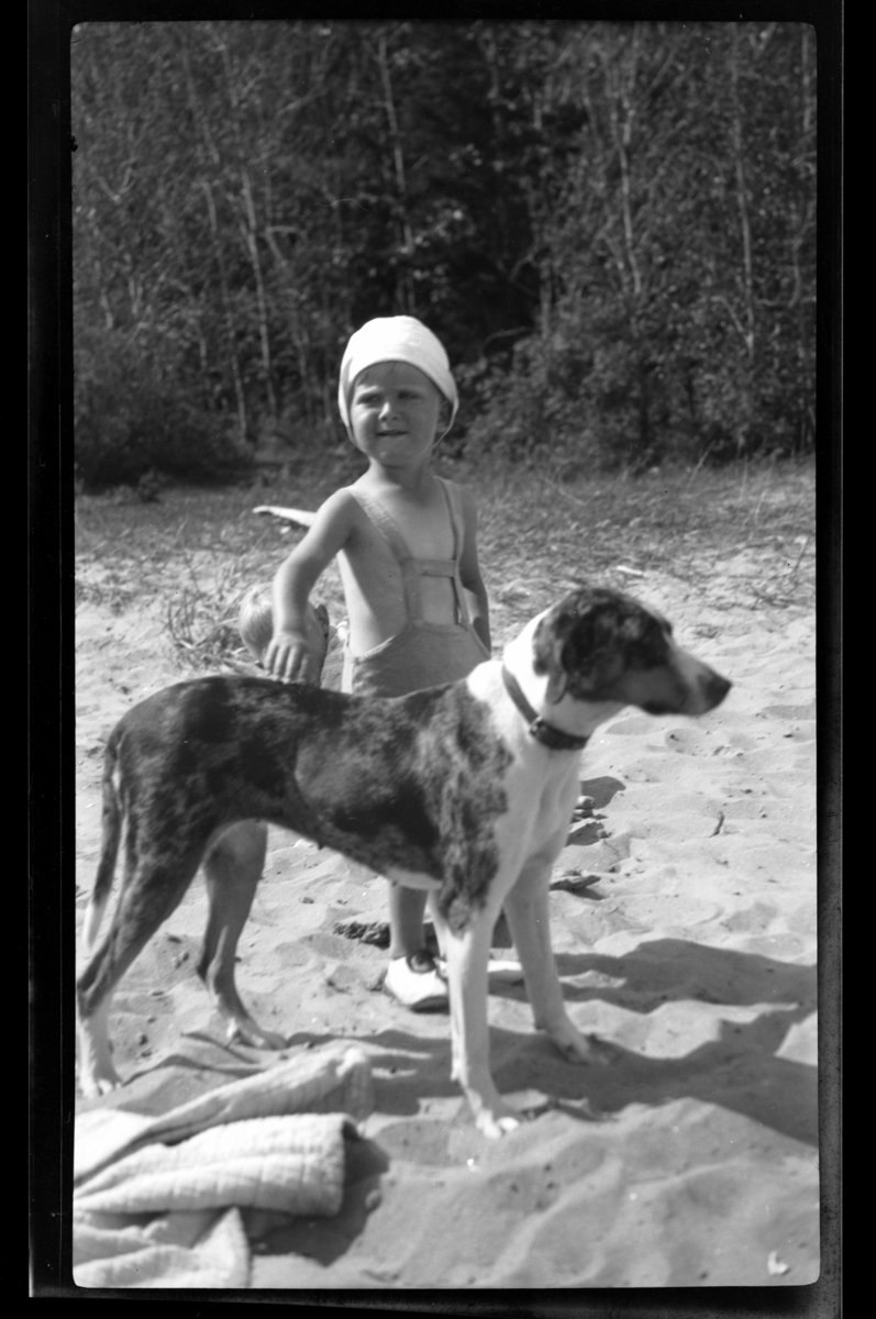 Rolf Sr. Sundt, Lars Peter Sundt med stor hund på en sandstrand på Ula i Vestfold. Fotografert 1932.