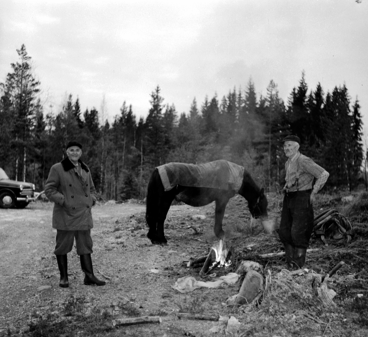 Anno Domkirkeodden, Skogbruksarbeidere. Hest med dekken. Nying, lite bål. To menn. Berger Langmoen AS, Brumunddal.