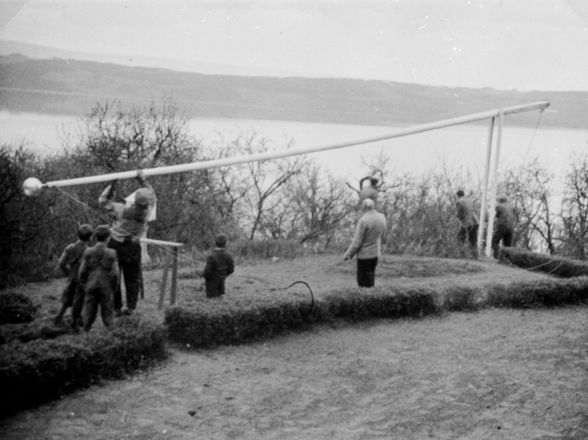 Anno Domkirkeodden, Ny line monteres på flaggstanga i hagen på Hovelsrud, Helgøya. Barn ser på. Den 7 mai 1945.