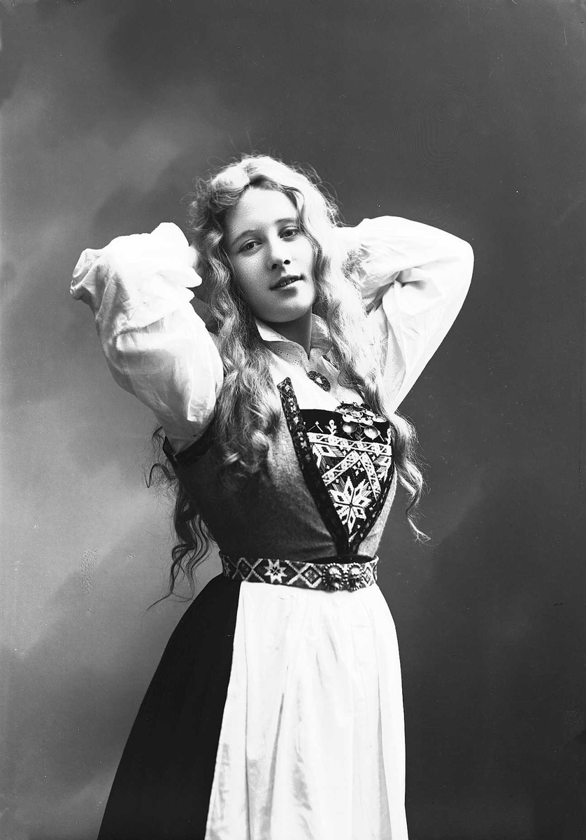 Solveig Lund, Studioportrett av kvinne i drakt med slett hår og armene bak hodet.