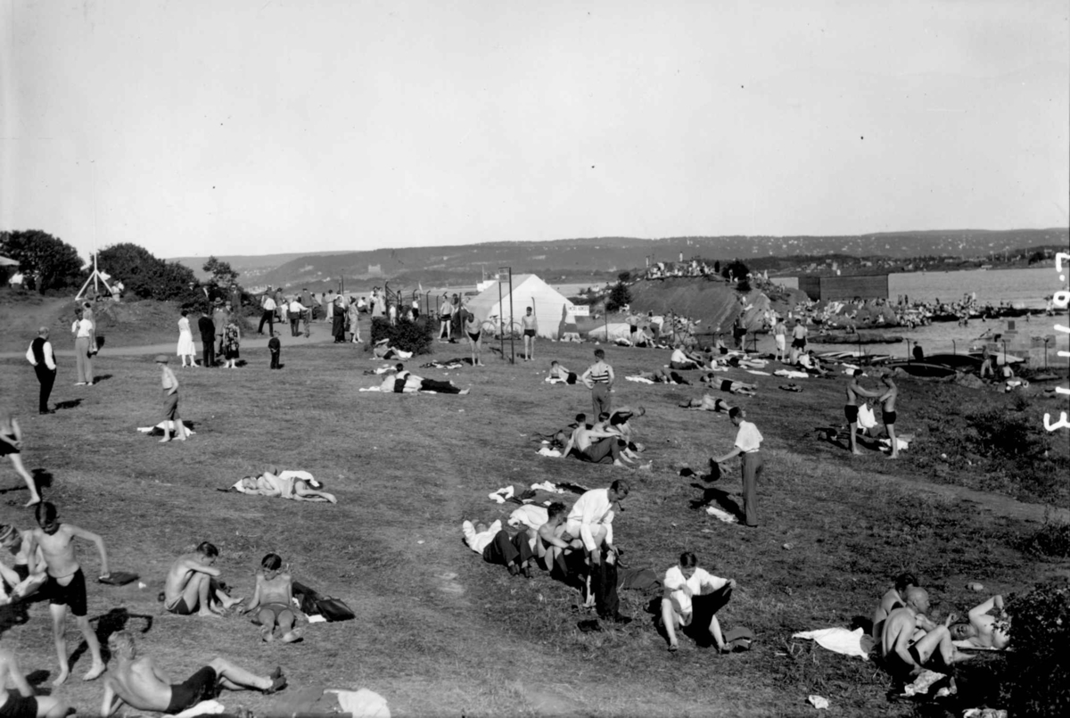 Hermann Christian Neupert, Oslo, Huk. Badeliv. Menn og unge gutter i badedrakt. Ekeberg i bakgrunnen.