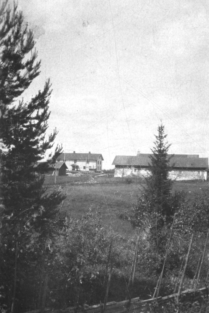 Ukjent, Øvre Tomter (60/1). Hovedbygningen i midten deler av drengestubygningen t.v., det gamle stenfjøset foran t. h.. Bak fjøset ser vi taket på låven med klokketårn. Ca 1920.
