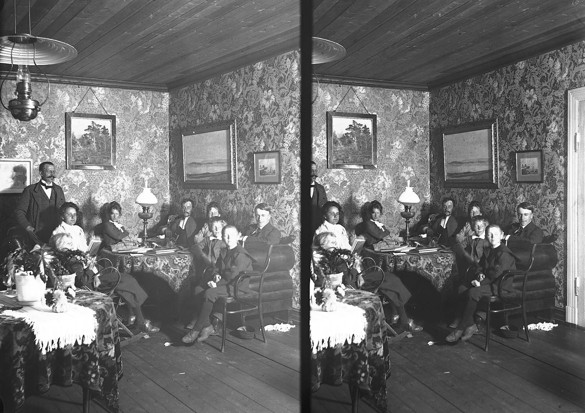 Axel Quinsgaard Wiborg, Interiør, Nedre Digerud, Frogn, Akershus, 1900-1901, hos familien Q. Wiborg. Gruppe sitter rundt bord med bøker. Personer på bildet: Herdis, Edle, Axel, Liv, Høyer-Ellefsen, Nina, David, Ingjald Bernts?, Tom Schreiner.