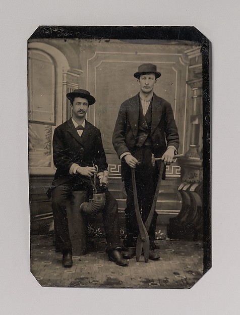 Unknown, [Two Stovepipe Makers, One with a Hammer and Tin Snips, the Other Sitting on Stovepipe Assembly with Tin Snips and Mallet]