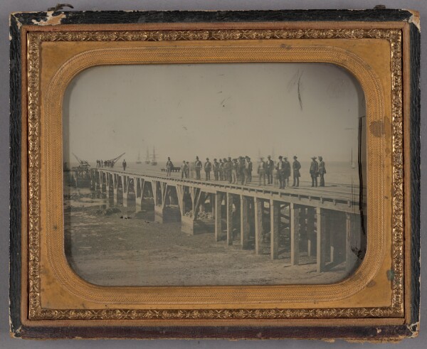 Unknown, [Group of Men on Loading Dock with Ships in Background]
