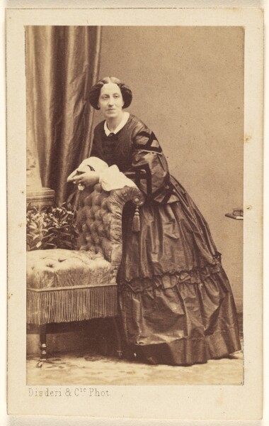 Disdéri & Cie., [Unidentified woman standing, leaning over the back of a chair]