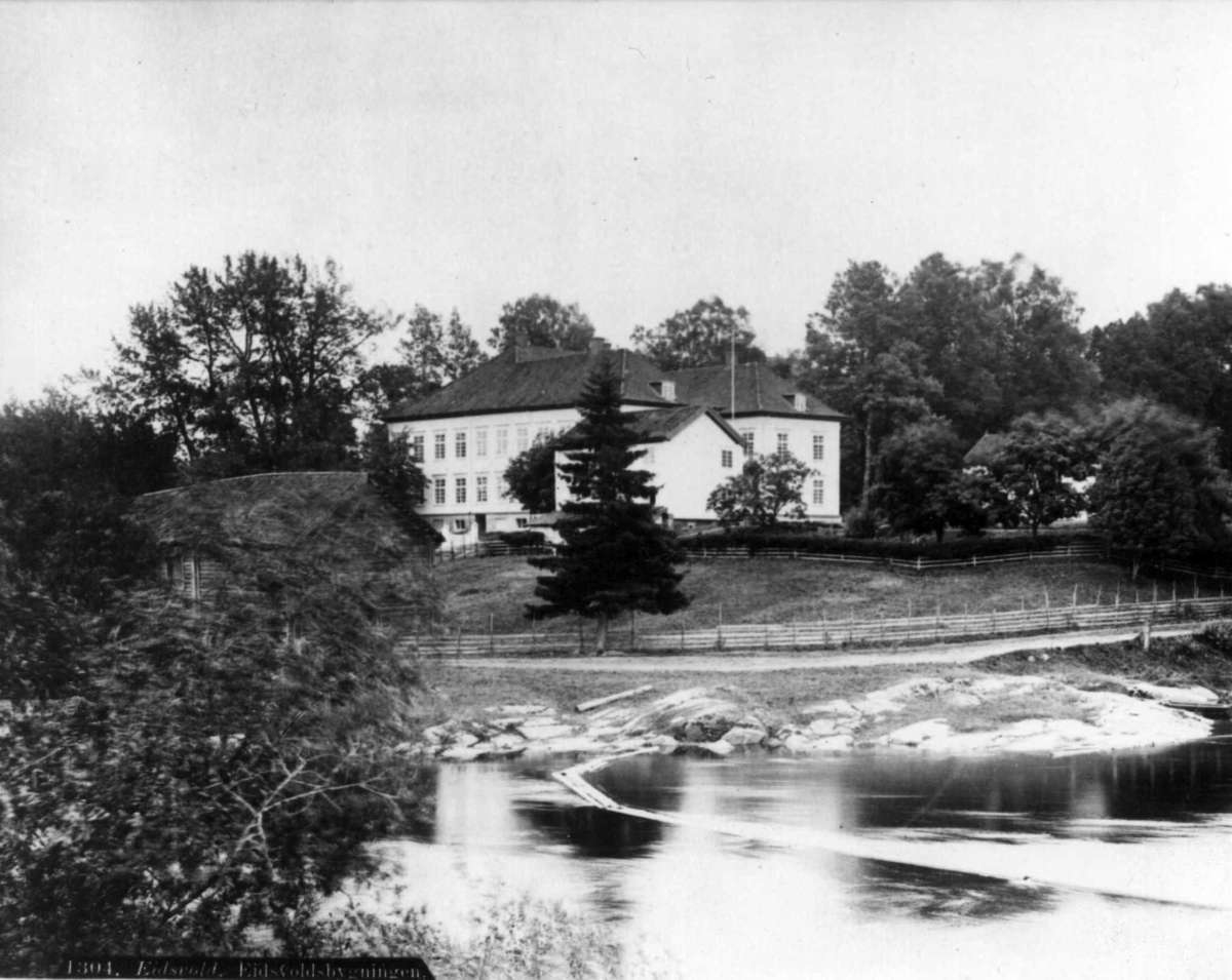 Axel Lindahl, Eisvollsbygningen, Eidsvoll, Akershus antagelig 1890-årene. Bygningen sett fra elva.