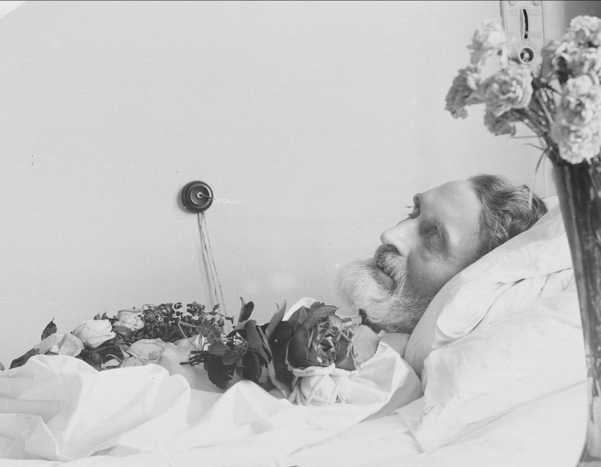 Gustav Borgen, Post mortem-fotografi. Død mann i pyntet seng. Trolig på sykehus.