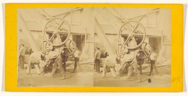 Unknown, [Man cranking a large machine]