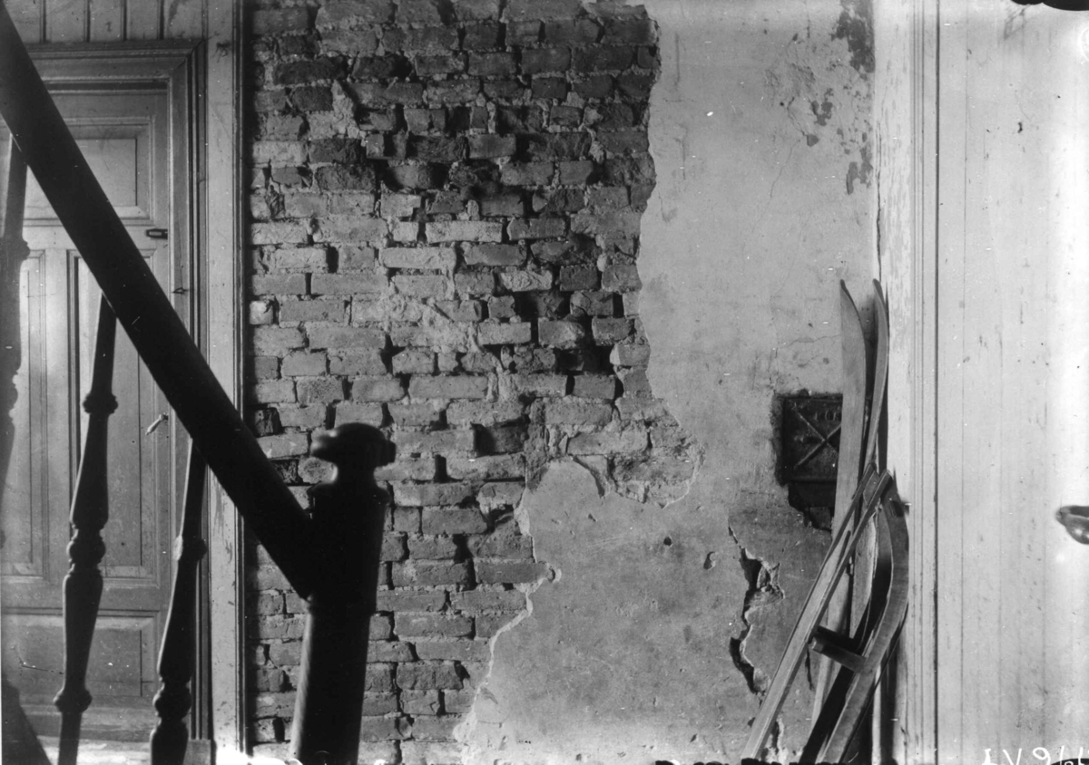 Nanna Broch, Trappeoppgang, Dynekilgata, Rosenhoff, Oslo. Avskallet murpuss. Kjelke og ski stilt opp mot veggen. Fra boliginspektør Nanna Brochs boligundersøkelser i Oslo 1920-årene.