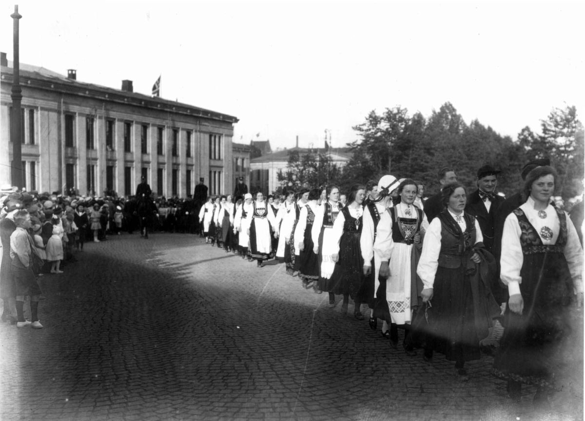 Hermann Christian Neupert, Nordisk Folkedansstevne ant. Karl Johans gate - Oslo. 1925. Opptog av norske og svenske folkedansere. Ridende politi. Universitetet i bakgrunnen.