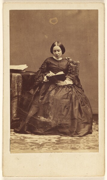 Disdéri & Cie., [Unidentified woman seated, reading a book]