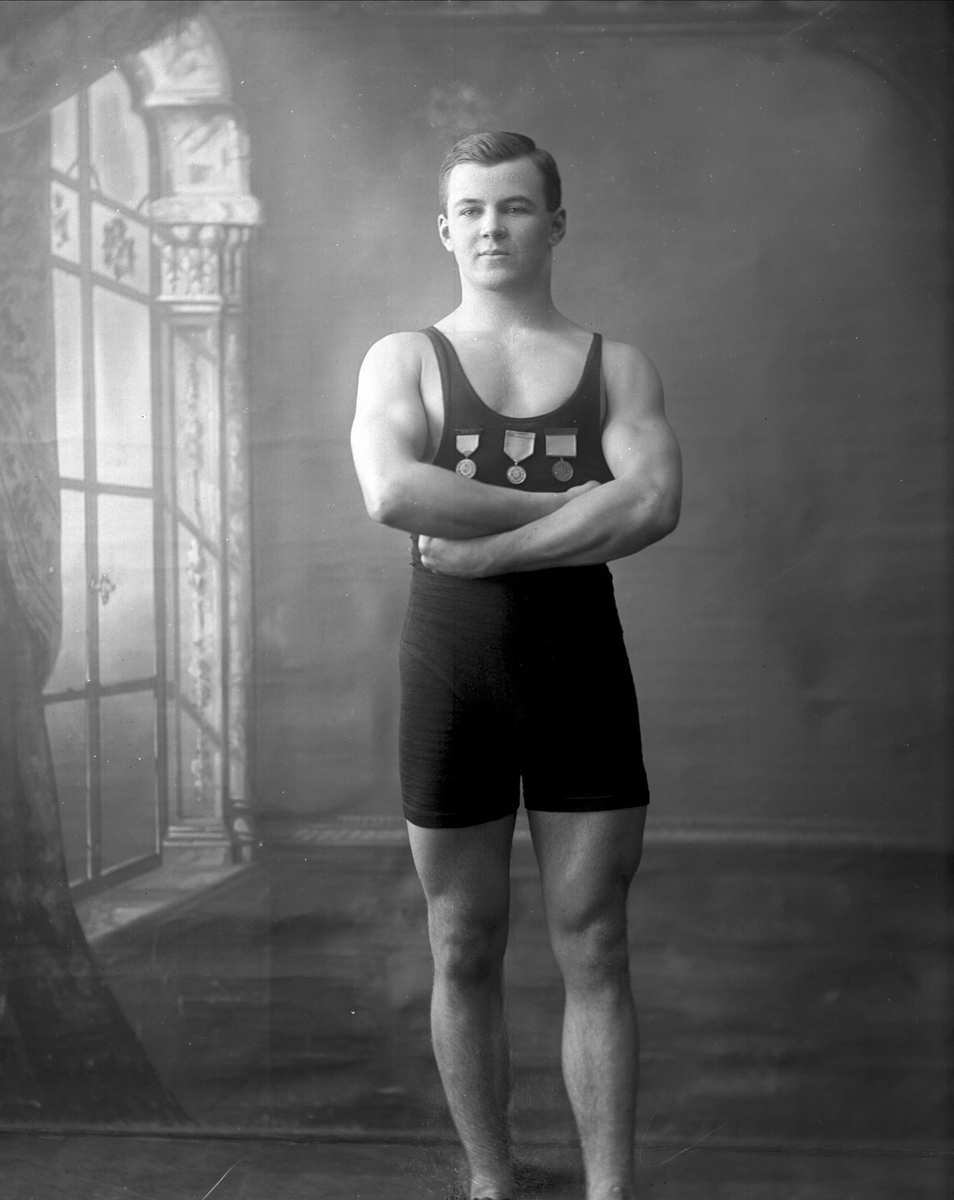 Gustav Borgen, Portrett, mann i bryterdrakt med medaljer. Frydenlund.