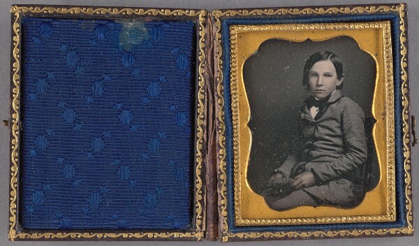 Unknown, [Portrait of a young boy seated, holding an unidentified object]
