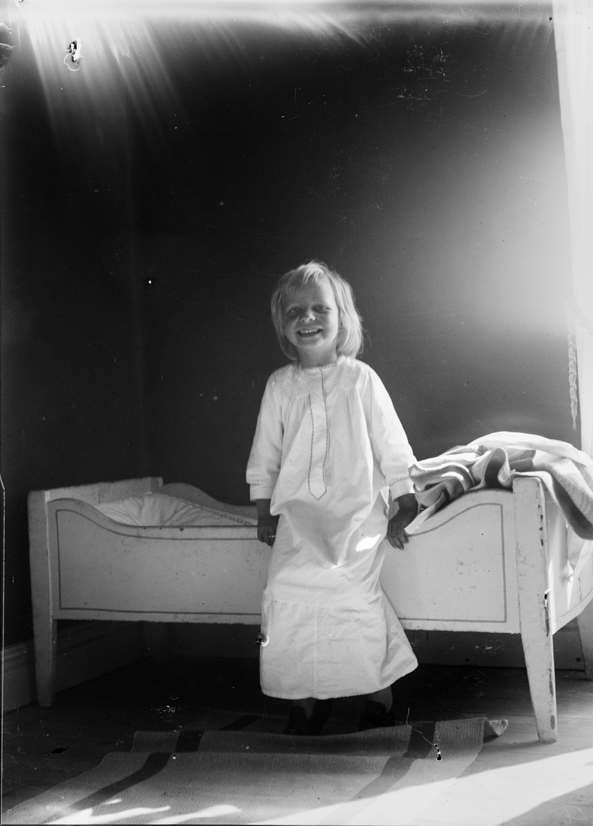 Okänd,, Christiane och Ruben Liljefors dotter Marit sittande på sängkanten, sannolikt i hemmet i Gävle