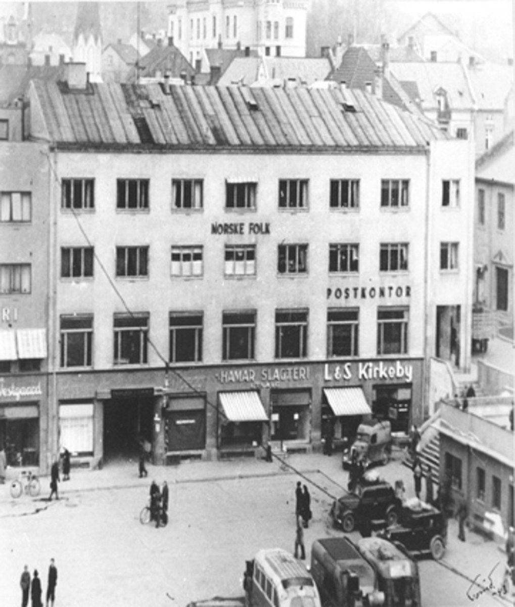 Anno Domkirkeodden, OVERSIKT POSTKONTORET VED ØSTRE TORG MED HAMAR SLAKTERI, L. & S. KIRKEBY OG NORSKE FOLK FORSIKRINGSSELSKAP, BILER OG BUSSER ER UTSTYRT MED GENERATORER, (KNOTTFYRING)