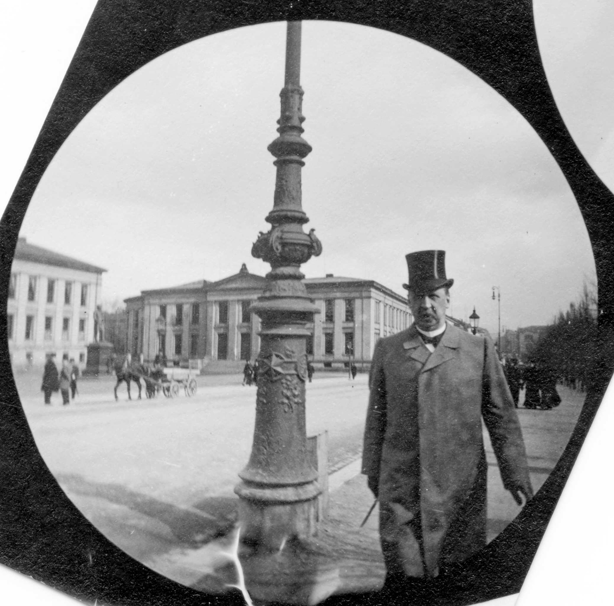 Fredrik Carl Mülertz Størmer, Apoteker Størmer med flosshatt ved siden av en lyktestolpe på Karl Johans gate, Oslo, med Universitetet i bakgrunnen.