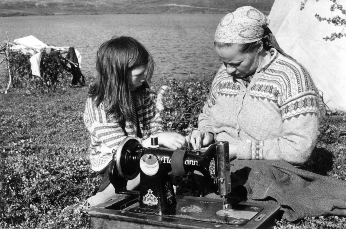 Virginia Raymond Davidson, Maskinsøm. Ellen Marie Anti syr kjole på symaskin til sin datter Karen Marie som står ved siden av. Isfjordfjellet 1959.