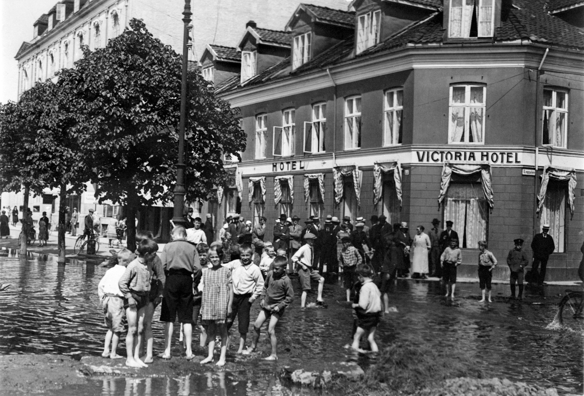 Anno Domkirkeodden, Mjøsflom, storflom i Mjøsa 1927. Barn leker i flomvannet i Strandgata, Hamar. Victoria hotell, Strandgata 21.