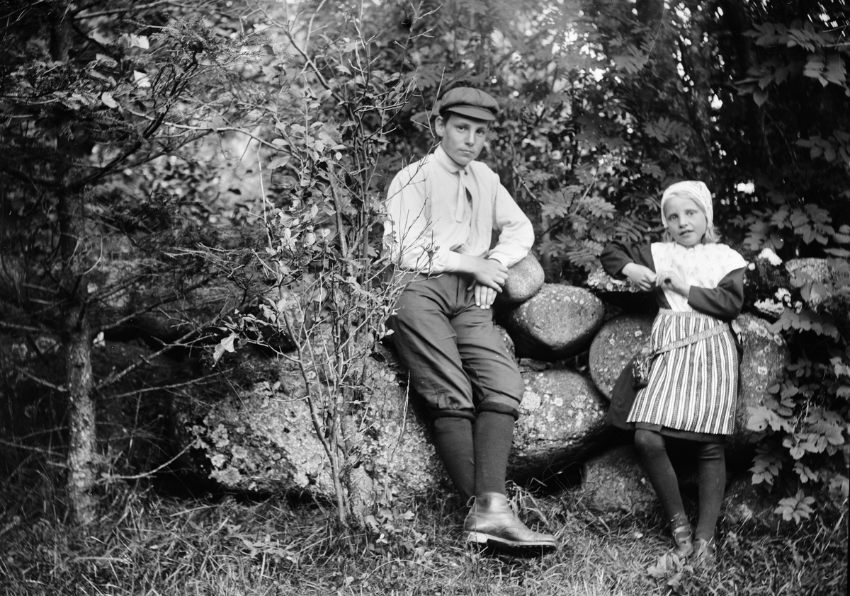 Okänd,, Ruben and Christiane Liljefors one son and daughter Marit stand by stone wall, probably Svensgården, Dalarna