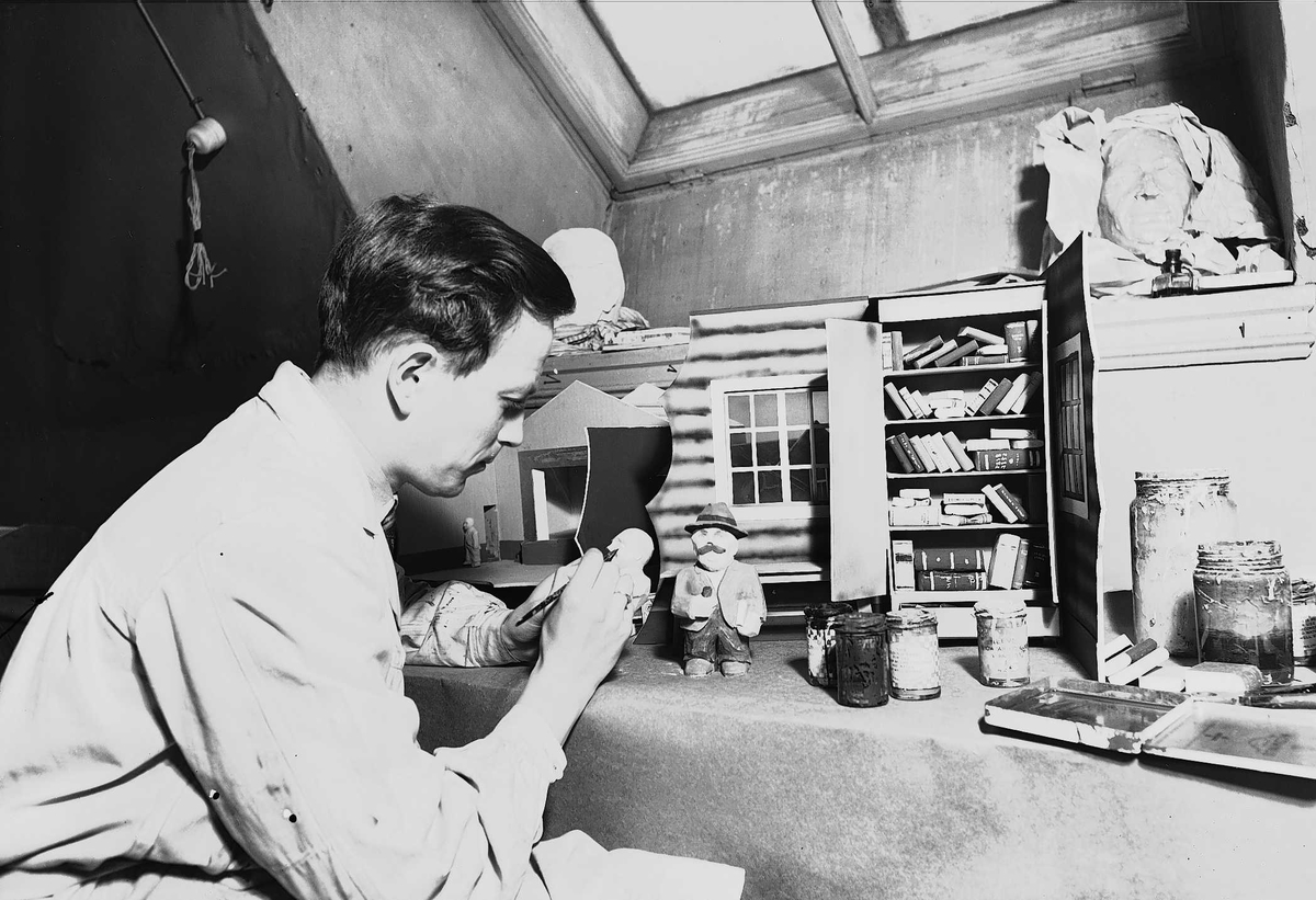 Axel Quinsgaard Wiborg, Thor Wiborg i arbeid med figurer til vindusutstillinger for "Arbeiderbladet", i sitt atelier med takvindu, Stenersgata 1, Oslo, ant. 1939.