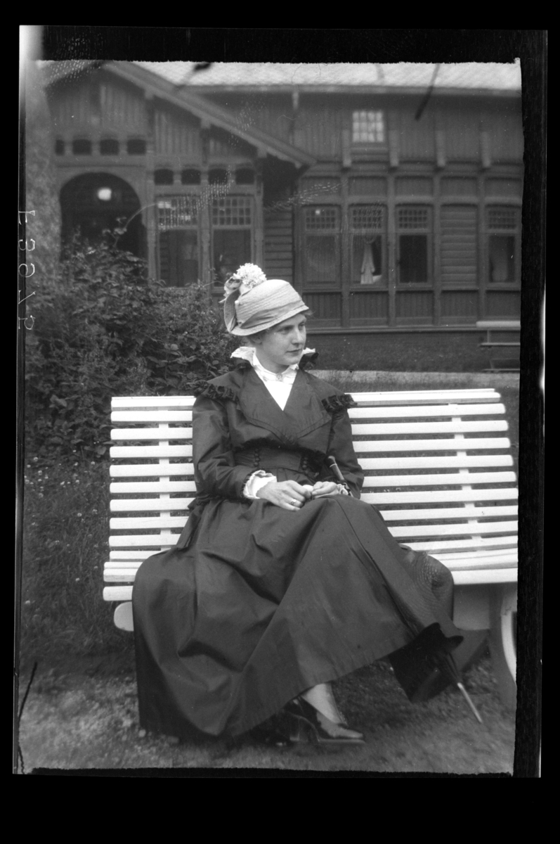 Rolf Sr. Sundt, Hilda Sundt sitter på en benk utenfor et trehotell.