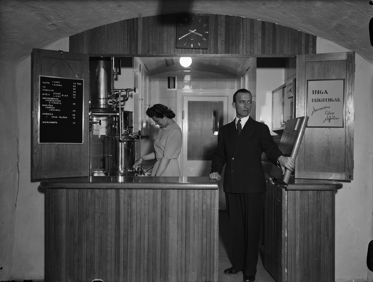Paul Sandberg, Torsten Walin framför disken, hans hustru brygger kaffe, nuvarande Café Alma, Universitetshuset, Uppsala 1941