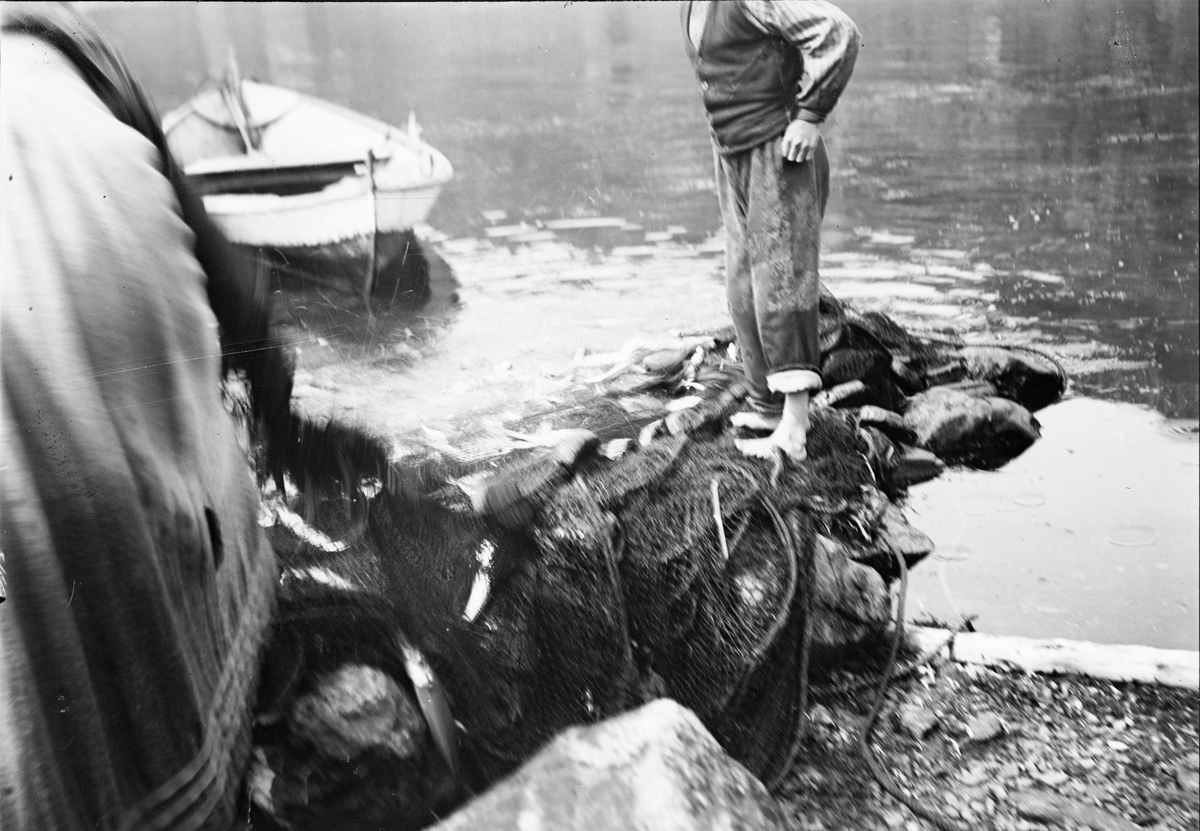 Okänd,, Fishermen with a fishing net and a boat at the shore, probably in Sweden