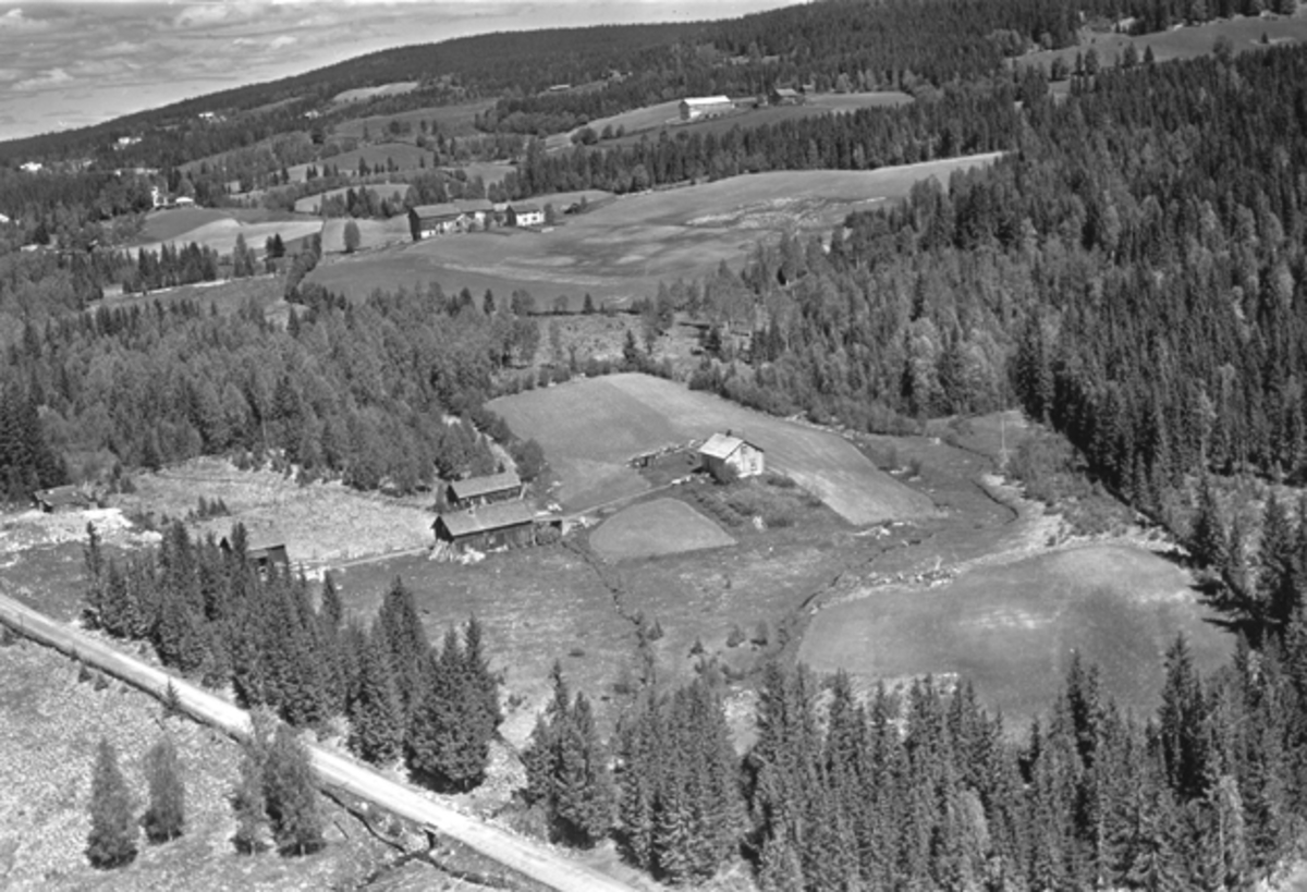 Widerøes Flyveselskap A/S, Flyfoto av Nybygda, Ringsaker. Bruket i forgrunnen er vel Jonsdal i Nybygda. Lenger bak er Aasdal og litt opp til høyre, Mæhlumsseter. Vegen mellom Nybygda og Putten nederst i venstre hjørne.