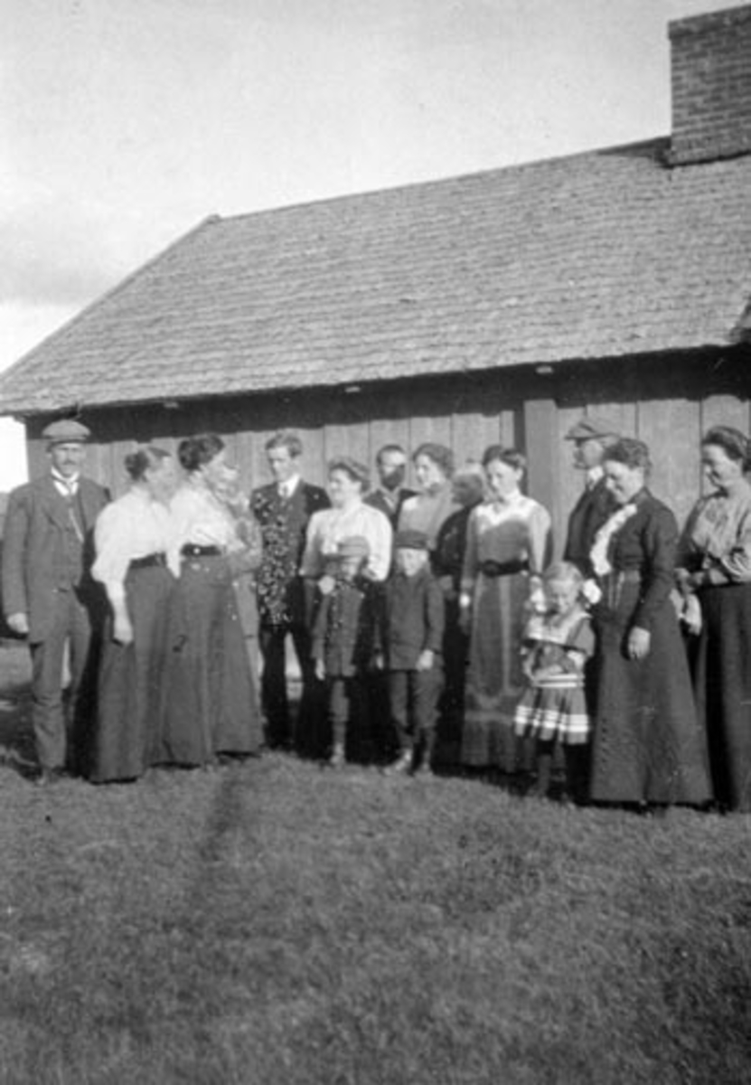 Anno Domkirkeodden, Voksne og barn foran størhus, Sjusjøen, Ringsaker Almenning. Fra venstre er Gunnar Berg, O.M. Engelstad, Johanne Hjelmstad, Signe Engelstad, ukjent, Rolf Stribolt, Eline Bergseng, Johs Herberg, Signe Herberg, Lovise Klundby, Margit Berg, Marthinus Berg,Nilla Larsen, ukjent. Barn er Christian Berg, …