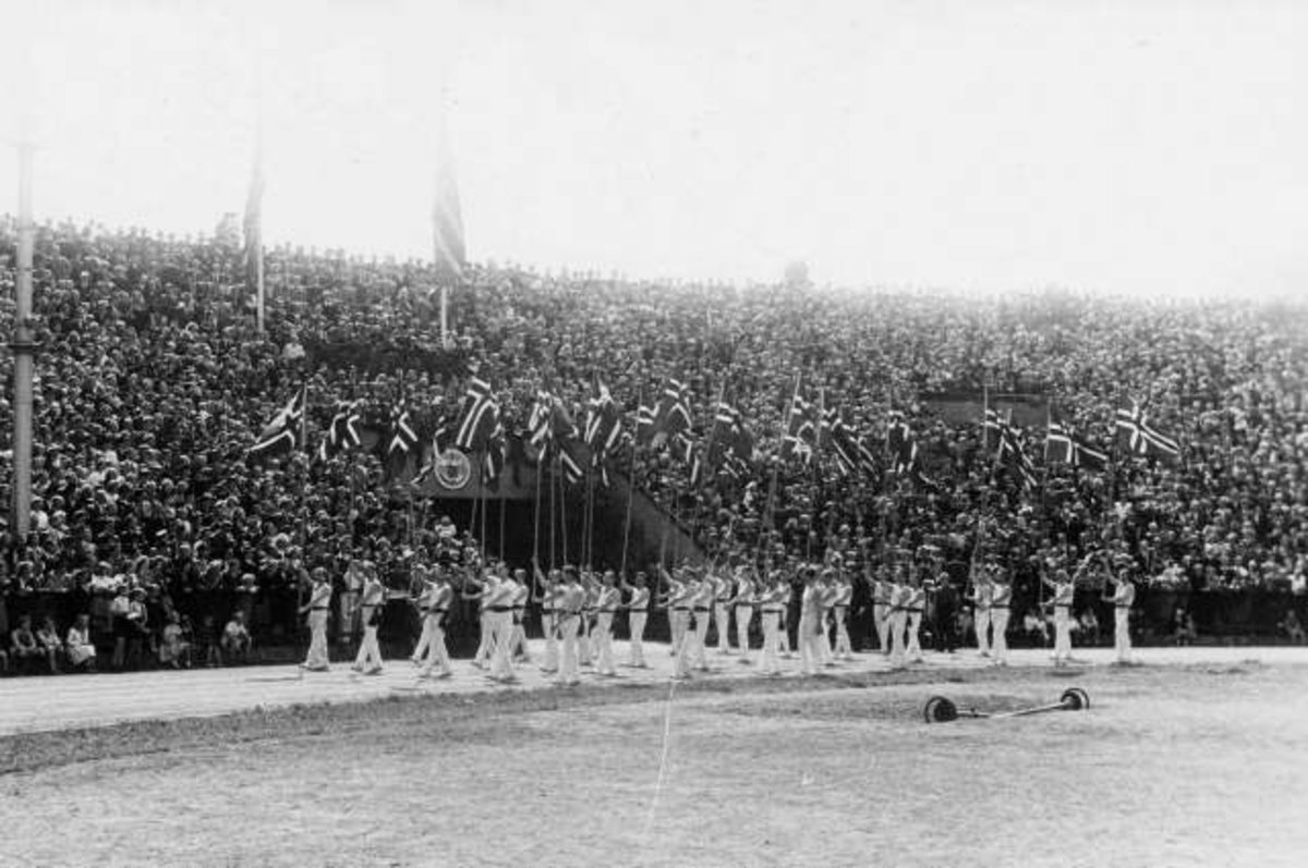 Anders Beer Wilse, Fra Oslo under fredsdagene i 1945. Idrettens Dag på Bislett Stadion 3.jun.Idrettsmenn med flaggborg på den oppmerkede banen.