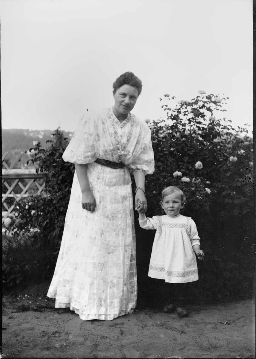 Okänd,, Christiane Liljefors med sin dotter Marit står i trädgård, sannolikt hos Christianes föräldrar i Stavanger, Norge