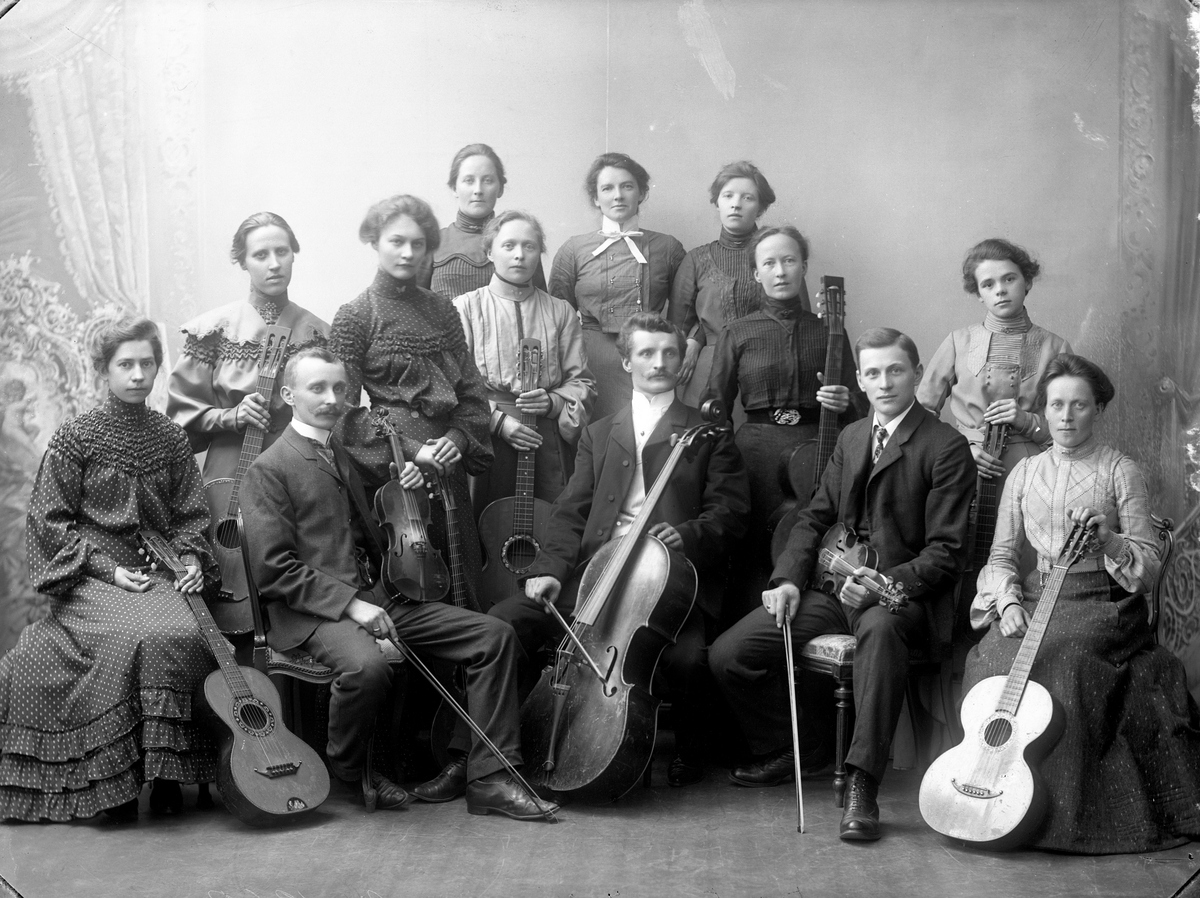 Gustav Borgen, Stor gruppe musikere med instrumenter. Feler, cello og gitarer. Familieorkester? Tapetserer J. Larsen.