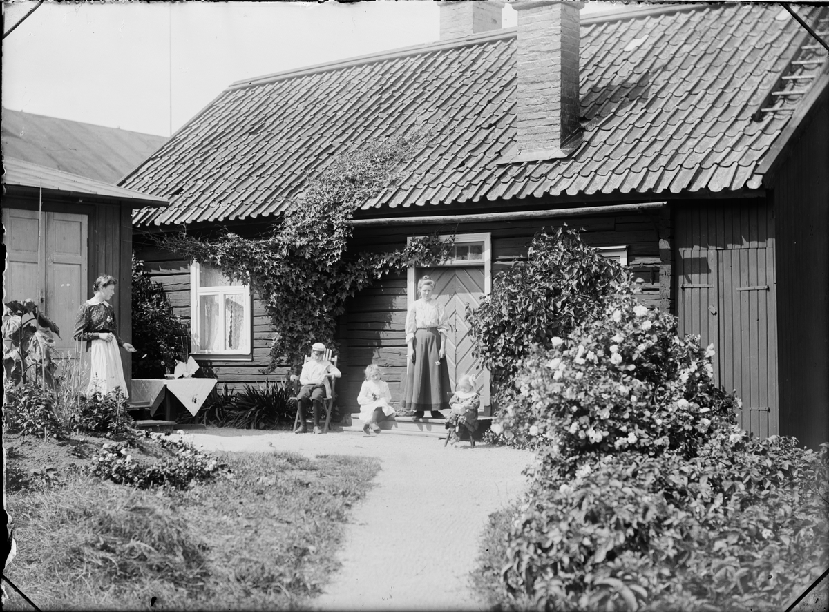 Skötsner-Edhlund, Guldskärskvarteret 25. Rebecka Andersson, Josef, Sara och Tyra Edhlund. Stående på trappan Ruth Skötsner, Östhammar, Uppland 1906
