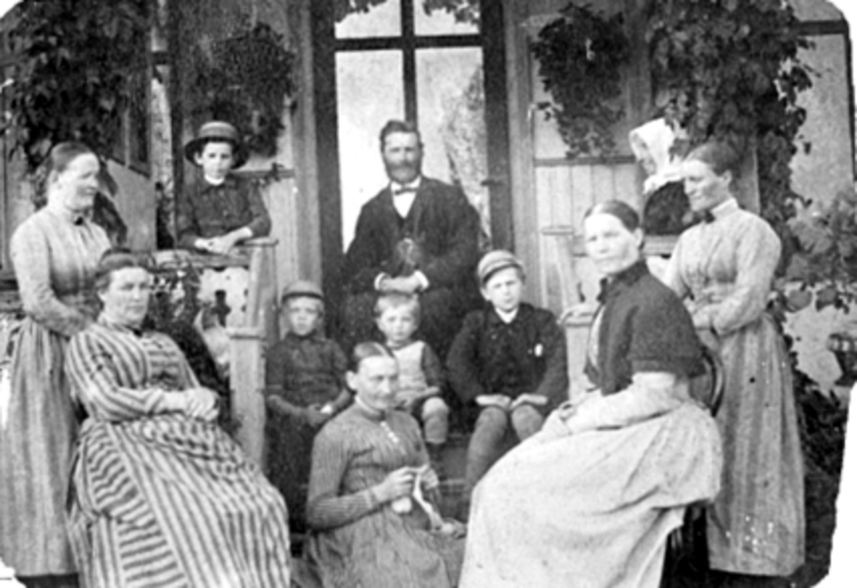 Anno Domkirkeodden, Gruppe, familie, Fredheim, St. Olavsgt. 95, Hamar. Foran fra v. fru stiftsprost Erichsen, bak henne barnepiken Guri, foran t. h Johanne Klungseth, bak henne Erichsens hushjelp Kari, i midten menighetssøster ukjent. På verandaen Nils Klungseth, Johanne Klungseths mor Lisbet Kristoffersdatter, gutten…