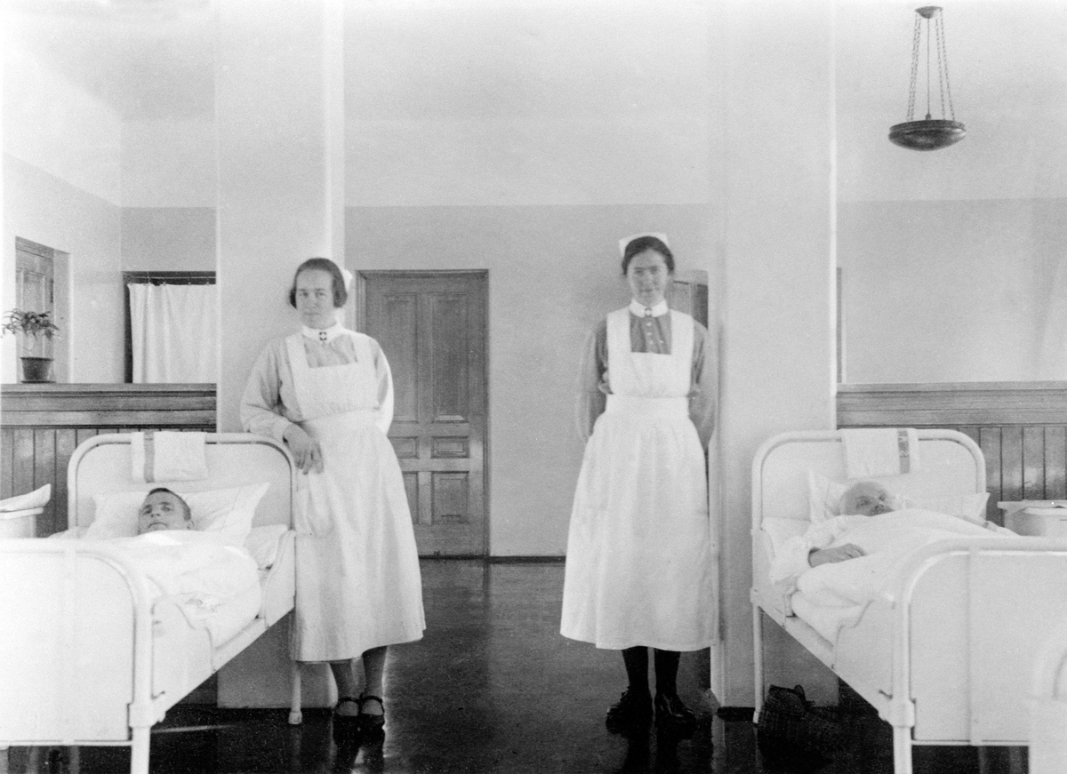 Anno Domkirkeodden, INTERIØR: 4. AVDELING SANDERUD SYKEHUS, PASIENTER TIL SENGS, GRUPPE: 2 PLEIERSKER, TIL VENSTRE: MARTA FOSSEID, HJELLUM. DENNE AVDELINGEN BLE BYGD I 1926SE ARTIKKEL I HA PLUSS 2. 2. 2008